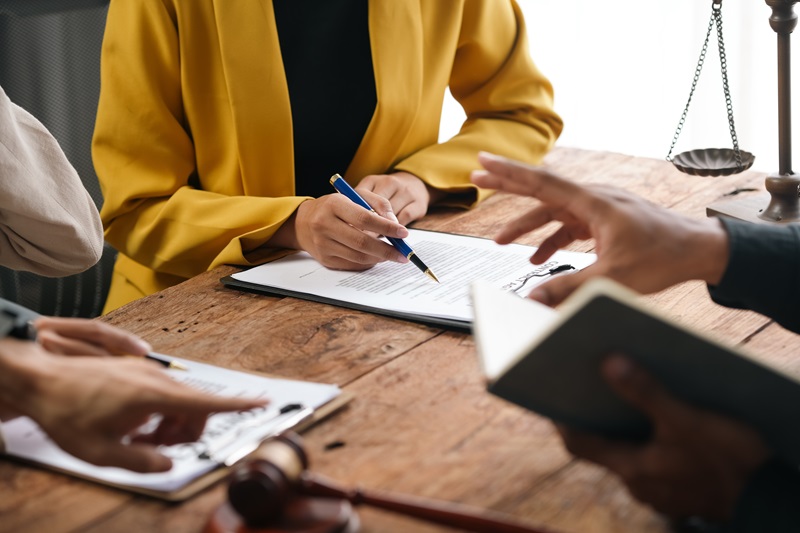 Lawyer is explaining contract details to client at a meeting in the office. They are discussing terms of agreement before signing